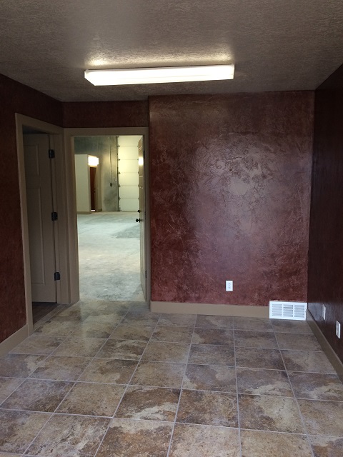 Finished office bay with tile flooring and textured accent wall