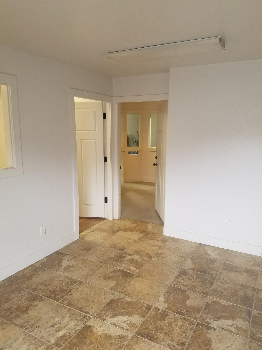 Finished office bay interior with tile flooring and hallway